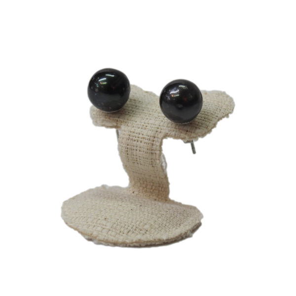 Black gemstone stud earrings on beige fabric display stand. Elegant jewelry from Island Craft Ltd since 1942.