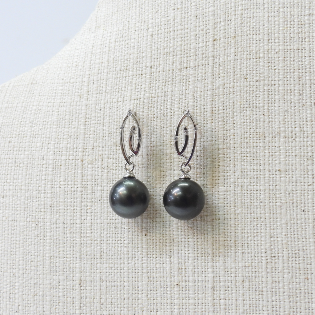 Elegant black pearl drop earrings featuring sterling silver hooks, crafted with precision since 1942.